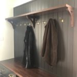 Graphite gray painted custom mudroom cabinets with walnut bench seat and shelf